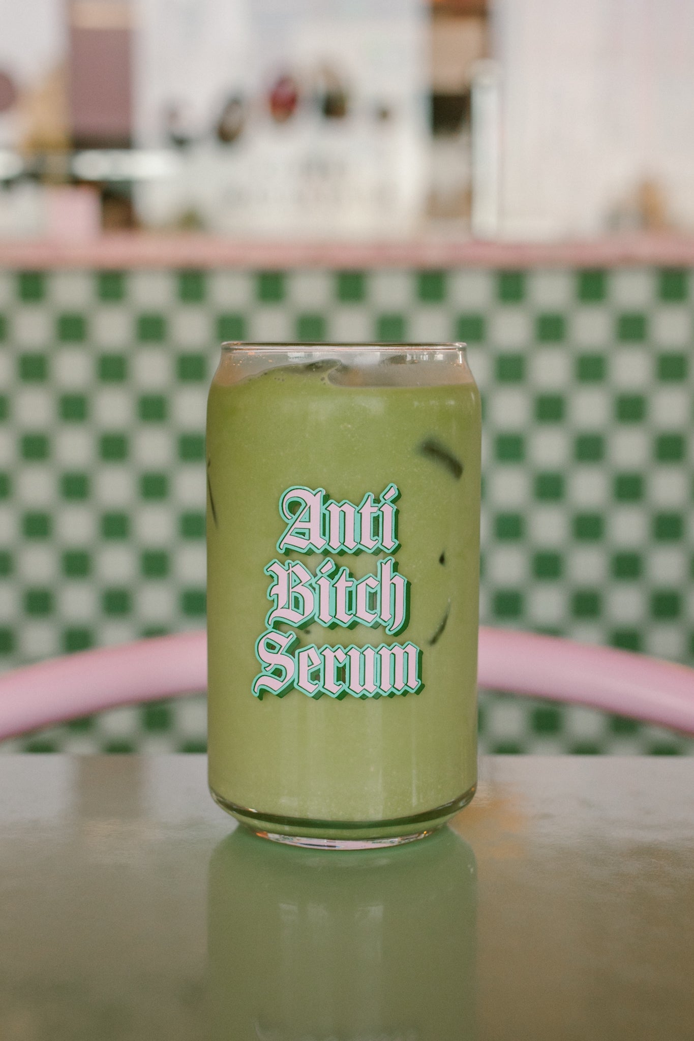 Green can with 'Anti Bitch Serum' text on a checkered background