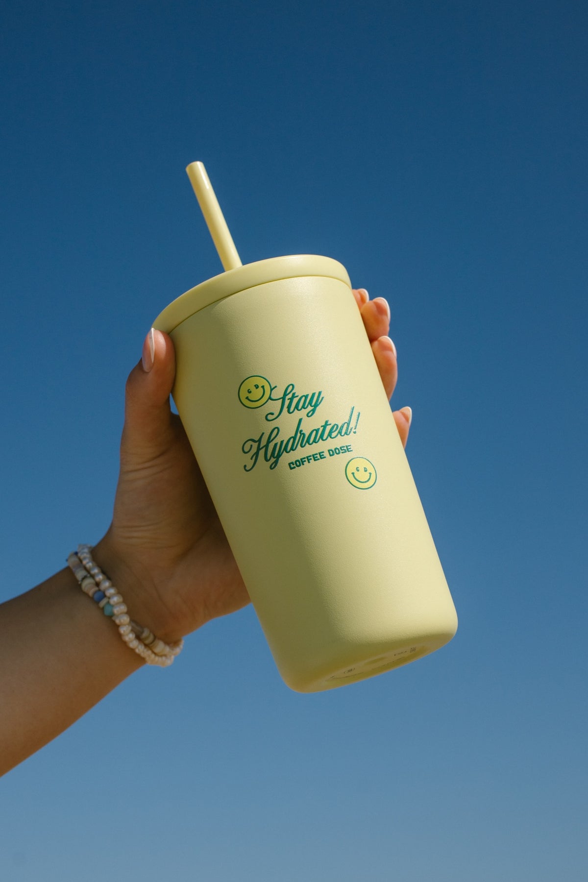 yellow cup with cursive 'stay hydrated' and smileys on the cup