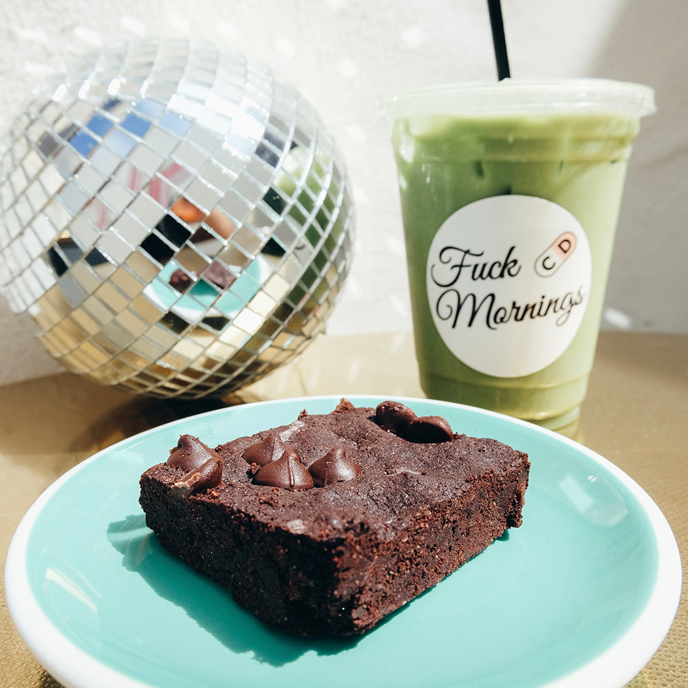 brownie on a plate with a green drink